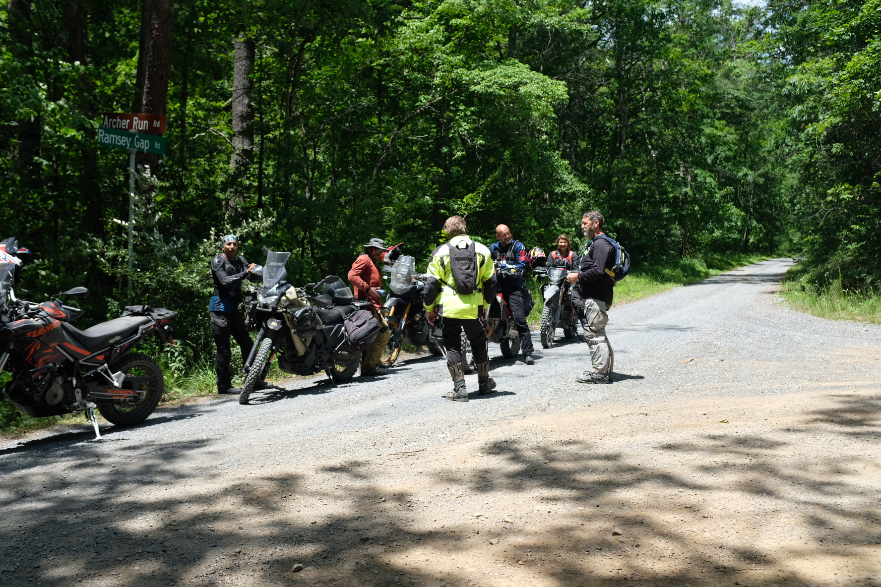 Group of riders talking at a forest road intersection during the Penmerryl Farm ride