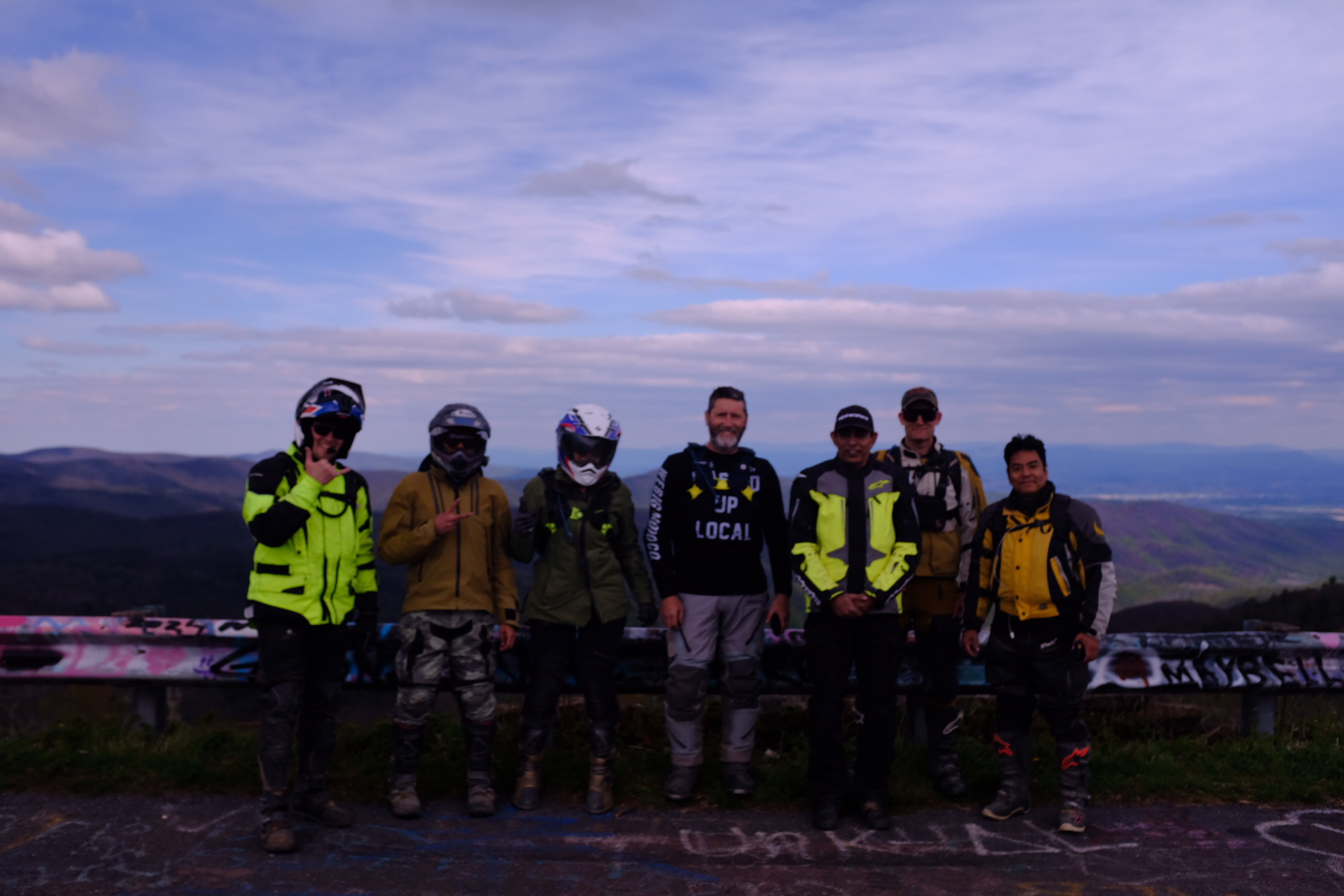 Riders gathered for a group photo at a mountain overlook