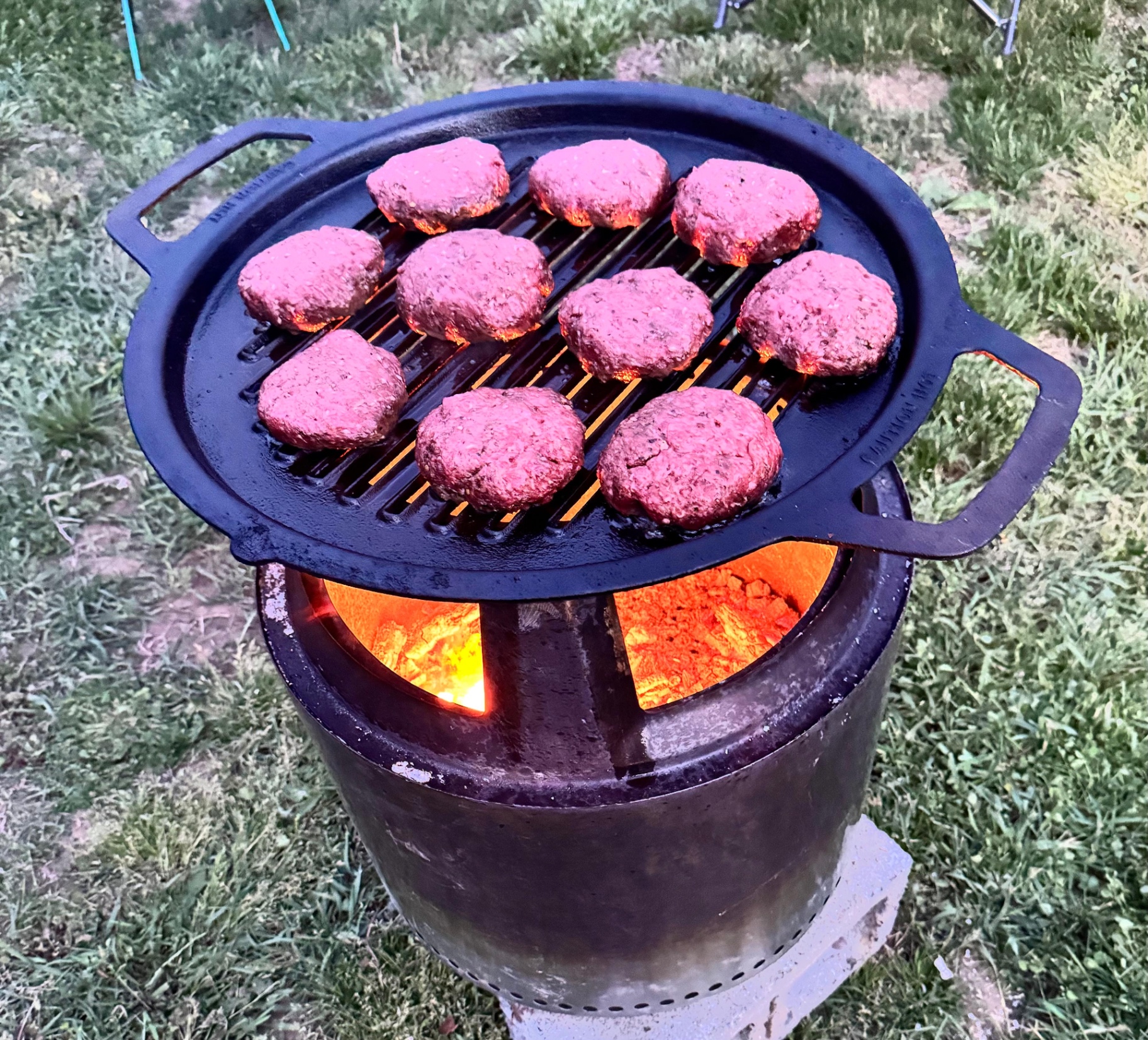 Hamburgers grilling over the open fire at camp
